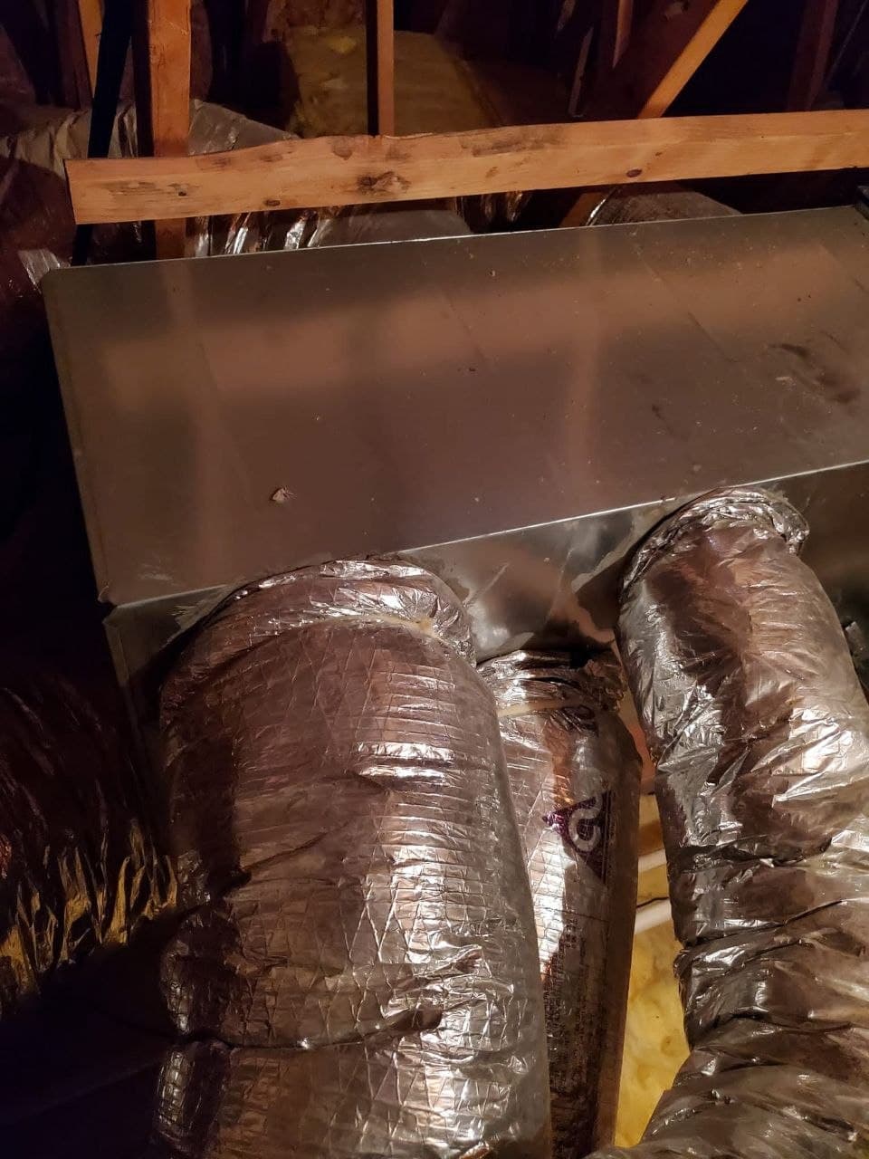 Insulated flexible ducts connected to a sheet-metal supply plenum in an attic